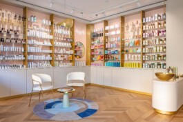 servizio fotografico interior design profumeria scaffali con profumi e sedie di design