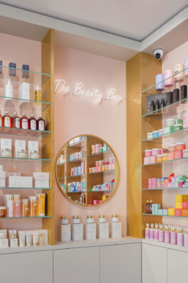 specchio tondo dorato e scritta al neon profumeria design bologna