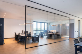 Open space degli uffici Ricci Casa con postazioni di lavoro e ampia vetrata 